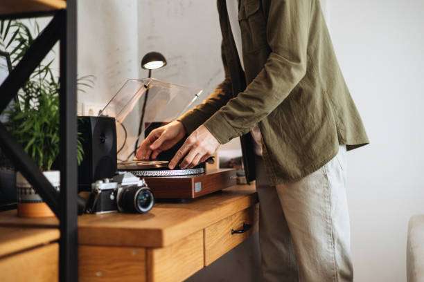 A man is playing music with a vinyl record player.