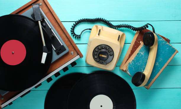 Vintage vinyl record player with LPs and rotary phone.